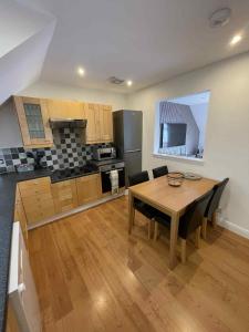 a kitchen with a wooden table and a dining room at Apartment in Banff in Banff