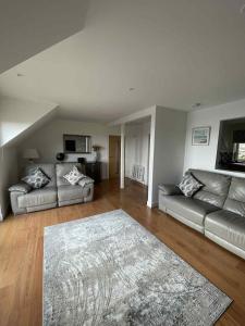 a living room with two couches and a rug at Apartment in Banff in Banff