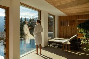 a woman standing on a porch looking at a bride through a window at Leni Mountain Chalet in Sölden