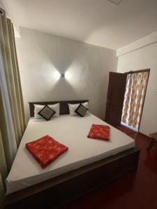 a bedroom with a bed with two red pillows on it at saffronvilla in Haputale +11 photos