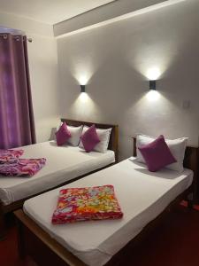 two beds in a hotel room with pillows on them at saffronvilla in Haputale