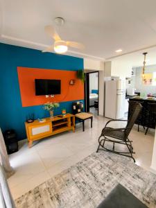 a living room with a tv on a blue wall at Apartamento Jacumã -Conde-PB in Conde