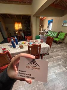 a person holding a sign in front of a dining room at Hospedaje Don Carmelo in El Peñón
