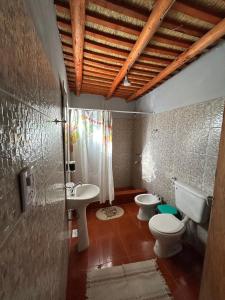 a bathroom with two toilets and a sink and a shower at Hospedaje Don Carmelo in El Peñón +23 photos