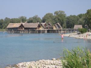 a woman is standing on a dock in the water at Barrierefreie Ferienwohnung Bodenseeblick in Unteruhldingen