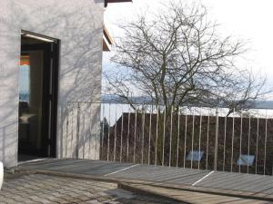 a building with a fence next to a tree at Barrierefreie Ferienwohnung Bodenseeblick in Unteruhldingen +3 photos