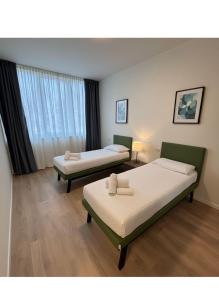 a room with two beds and a window at SPACE101 City Apartment & Studio in Limito di Pioltello +36 photos