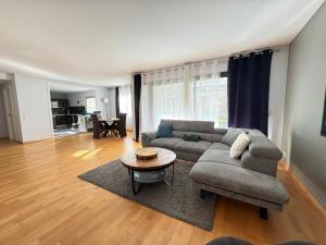 a living room with a couch and a table at Big Flat - Direct CERN in Saint-Genis-Pouilly