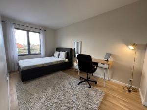 a bedroom with a bed and a desk and a desk at Big Flat - Direct CERN in Saint-Genis-Pouilly