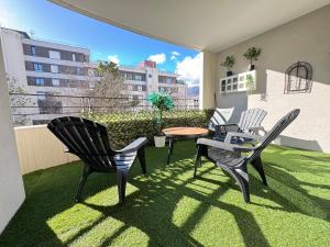 a patio with two chairs and a table on the grass at Big Flat - Direct CERN in Saint-Genis-Pouilly