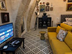 a living room with a yellow couch and a tv at 3 Doni in Rabat