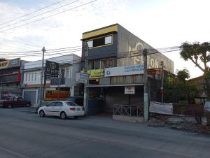 a small white car parked in front of a building at RnR Suites in Dagupan