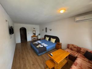 ein Wohnzimmer mit einem blauen Bett und einem Tisch in der Unterkunft Hotel Gamartata in Duni