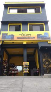 a store front with a yellow and blue building at RnR Suites in Dagupan