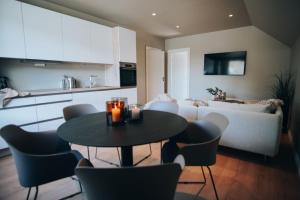 a kitchen and a living room with a table and a couch at Odda Apartments - 2BR & 3BR - Parking - T32 in Odda