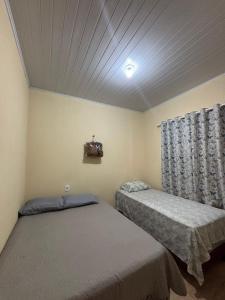 two twin beds in a room with a ceiling at Apartamento Lençóis in Barreirinhas
