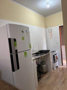 a kitchen with a white refrigerator and a stove at Apartamento Lençóis in Barreirinhas