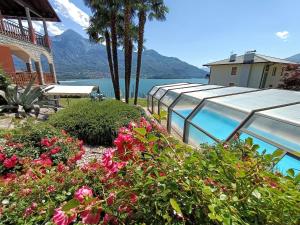a house with a swimming pool and some flowers at Residence Casa Rosa in Gera Lario
