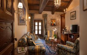 a living room with a couch and chairs and a television at Hotel Castello Di Sinio in Sinio