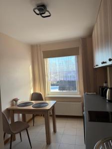 a small kitchen with a table and a window at Dzīvoklis Bauskā in Bauska +3 photos