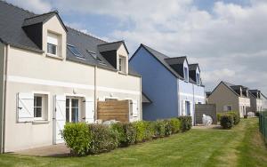 a row of houses with a dog walking in the yard at Pentrez Cottage - 600m de la Plage in Saint-Nic