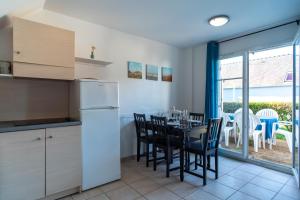 a kitchen and dining room with a table and chairs at Pentrez Cottage - 600m de la Plage in Saint-Nic +10 photos