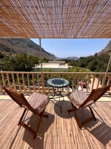 a patio with two chairs and a table on a deck at Kalotina's Home in Kalymnos