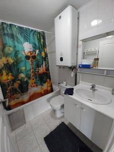 a bathroom with a sink and a toilet and a shower curtain at Menton 1 in Menton