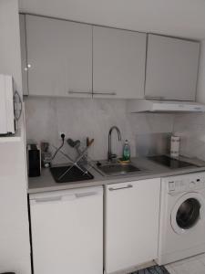 a white kitchen with a sink and a washing machine at Menton 1 in Menton