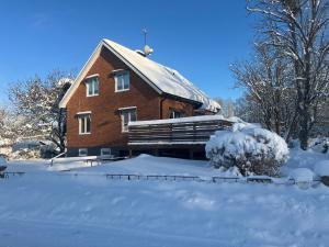 a large brick house with snow on the ground at Ferienhaus in Orrefors in Orrefors