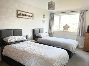 a bedroom with two beds and a window at Cedar Place in Southwell in Southwell