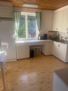 a kitchen with white cabinets and a window at Ferienhaus in Orrefors in Orrefors +11 photos