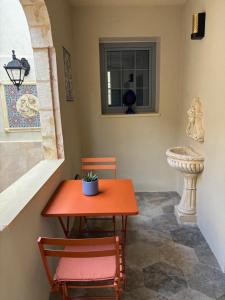 an orange table and chairs in a room with a window at 3 Doni in Rabat