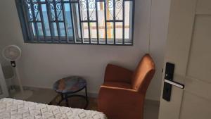 a room with a bed and a chair and a window at Ivan John Guest home in Number Two Village
