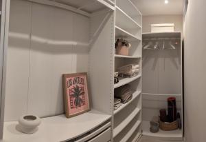 a walk in closet with white walls and glass doors at La Perle in Marseille +2 photos