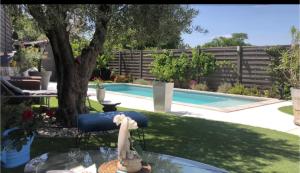 a backyard with a swimming pool and a bird sitting on a chair at La Perle in Marseille