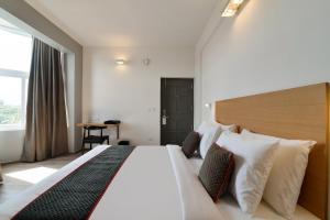 a hotel room with a large bed and a table at Townhouse Srm Kuppakonam Pudur in Coimbatore