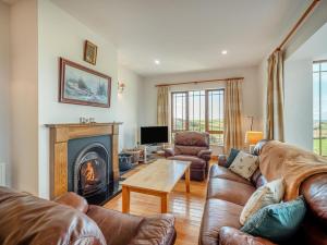 a living room with leather furniture and a fireplace at 3 Bed in Renvyle oc-i254 in Cashleen