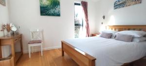a bedroom with a large white bed and a window at The Gallery Lodges in Braunton