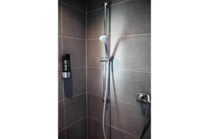 a shower with a shower head in a bathroom at Bendorf Hotel by Belvilla in Bendorf