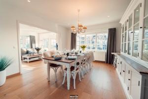 a kitchen and dining room with a table and chairs at Villa Promenade - luxuriously apartment for 8 people in Nieuwpoort