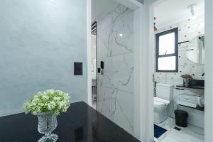 a bathroom with a vase of flowers on a table at Condominio da Americas Maspex in São Paulo +24 photos