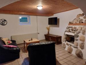 a living room with a stone fireplace and a tv at Ferienhaus Wohleser in Mariahof