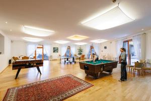 a man standing in a living room with pool tables at Gartenhotel Rosenhof bei Kitzbühel in Oberndorf in Tirol