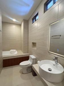 a bathroom with a white toilet and a sink at Hotel Taxaha in Candelaria