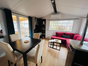 a living room with a red couch and a table at MH J08 - Camping Siblu La plage in Mimizan-Plage