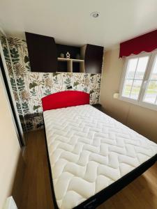 a bedroom with a large white bed with a red pillow at MH J08 - Camping Siblu La plage in Mimizan-Plage +16 photos
