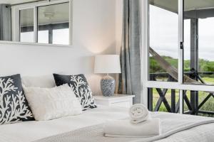 a bedroom with a bed with a large window at Adrift - Oceanfront - Pets Welcome in Middleton