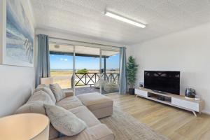a living room with a couch and a flat screen tv at Adrift - Oceanfront - Pets Welcome in Middleton