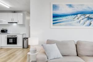 a living room with a couch and a kitchen at Adrift - Oceanfront - Pets Welcome in Middleton